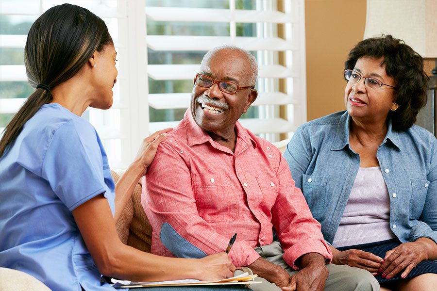 Senior Living Facility Insurance - Home Nurse Meeting with Older Couple in the Living Room