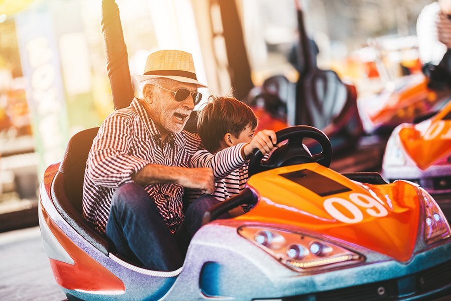 Blog - Grandfather and Grandson Having Fun Together at an Amusement Park