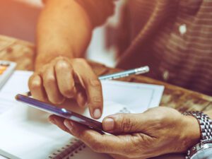 Contractor looking through their phone while going over plans