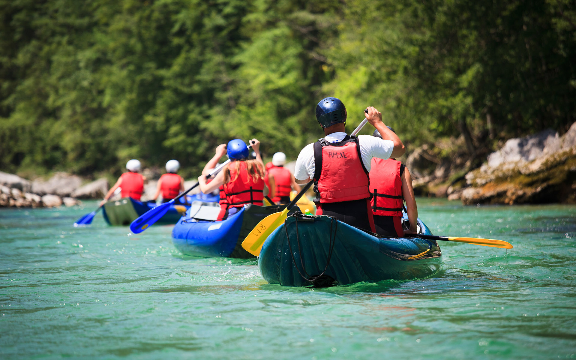 River Outfitter Insurance Guide - Group of People River Rafting on a Calm River in Between a Forest of Pine Trees