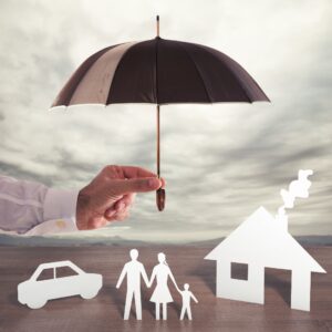 umbrella over paper cutouts of car, house, and family