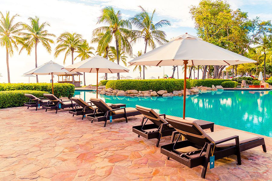 Hot Spring Spa and Resort Insurance - View of Lounge Chairs by the Pool in a Tropical Resort on a Sunny Day