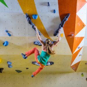 woman rock climbing at climbing gym